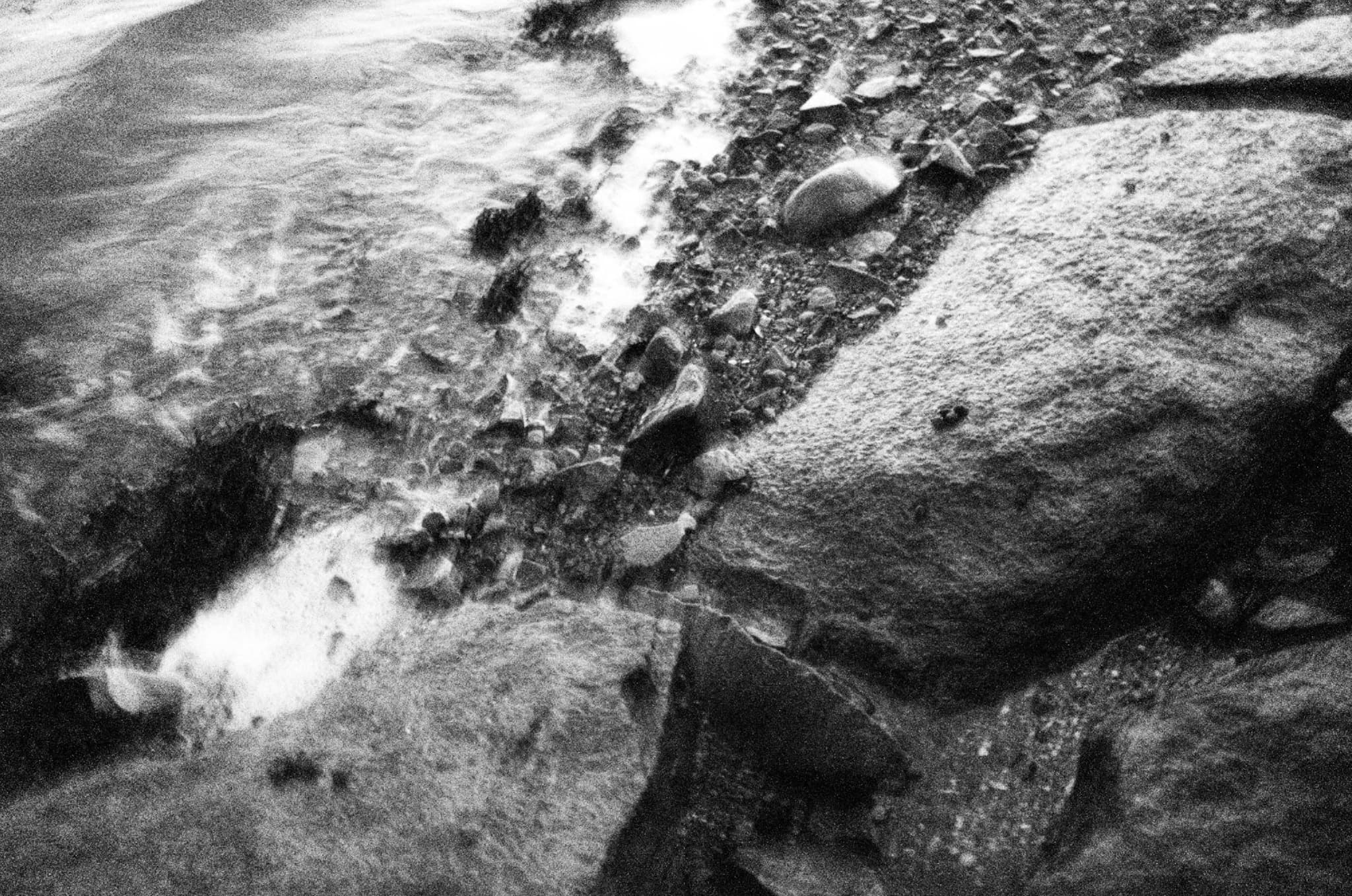 Image of amalgamated rocks on a shoreline with a slight blur effect